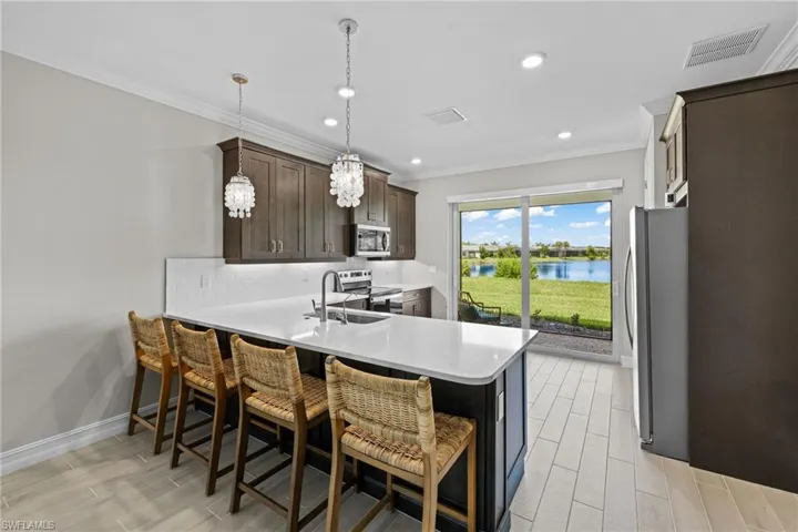 Kitchen with tasteful backsplash, stainless steel appliances, sink, kitchen peninsula, and a water view