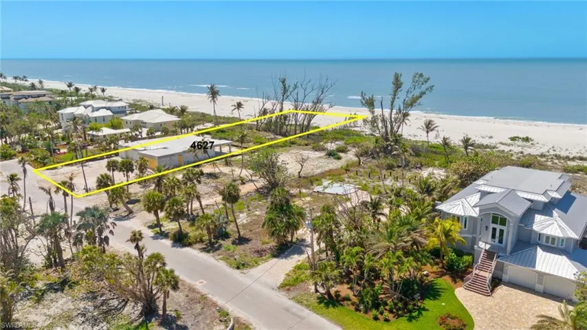 Birds eye view of property featuring a beach view and a water view