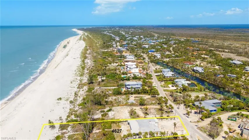 Birds eye view of property featuring a beach view and a water view