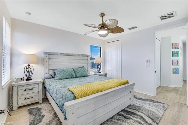 Bedroom featuring ceiling fan, a closet, and light wood-type flooring