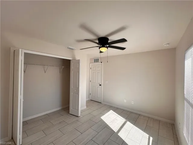 Unfurnished bedroom with a closet, a ceiling fan, and wood tiled floors