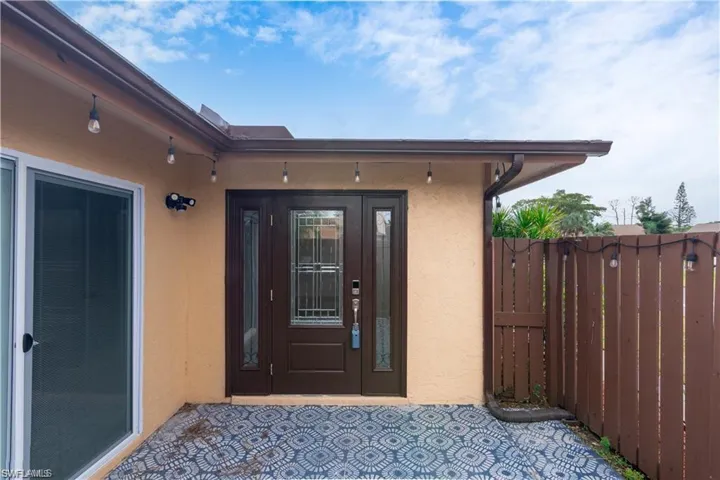 Doorway to property with stucco siding and a patio area
