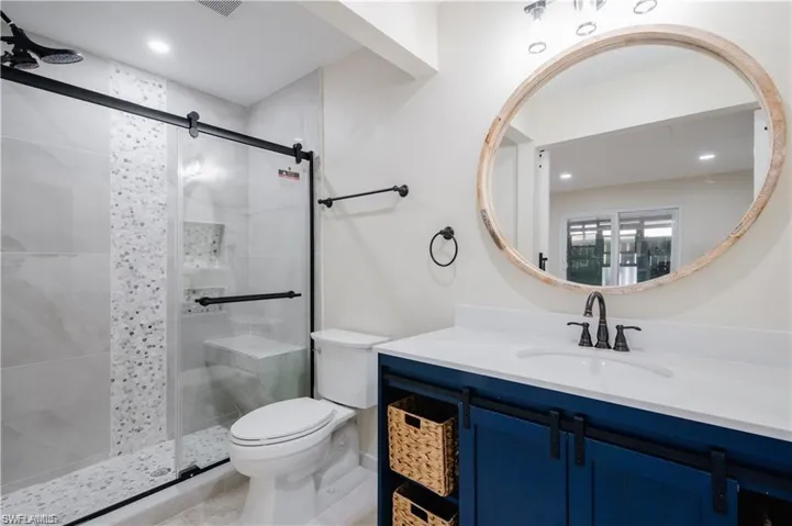 Full bath with a shower stall, vanity, recessed lighting, and tile patterned floors