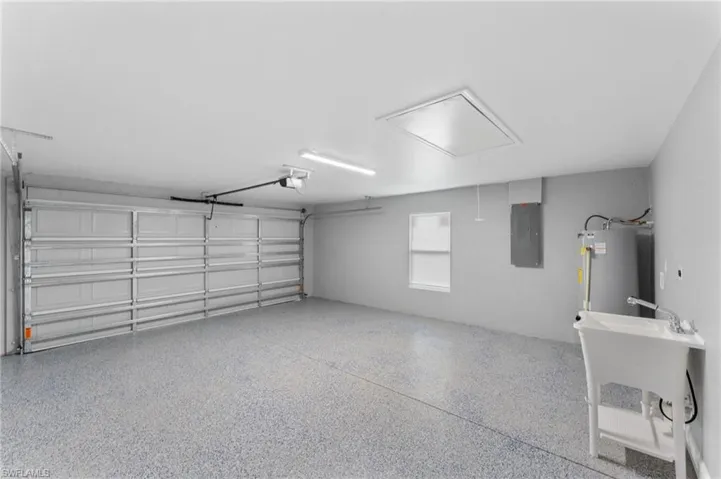 Garage featuring electric panel and water heater