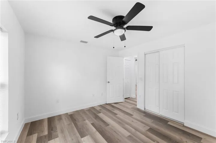 Unfurnished bedroom featuring light wood finished floors, ceiling fan, and a closet