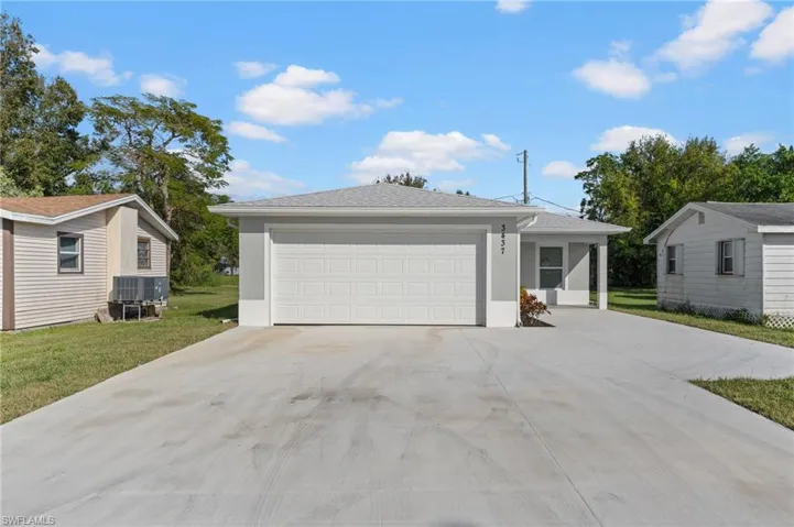 View of front of house featuring concrete driveway, a garage, a front yard, stucco siding, and roof with shingles