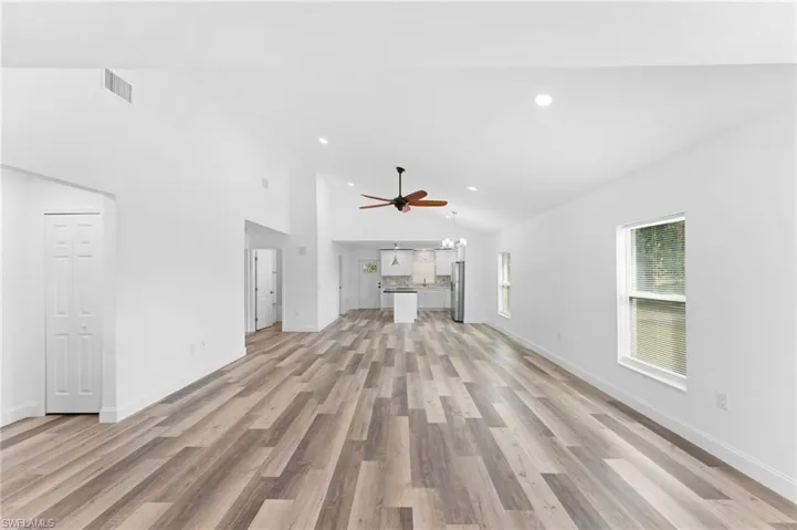 Unfurnished living room featuring light wood-type flooring, high vaulted ceiling, recessed lighting, and a ceiling fan