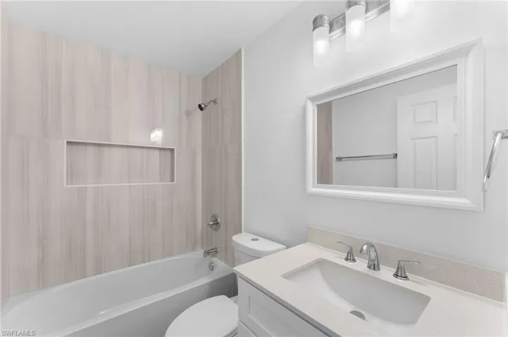 Bathroom featuring shower / washtub combination, vanity, and a textured wall