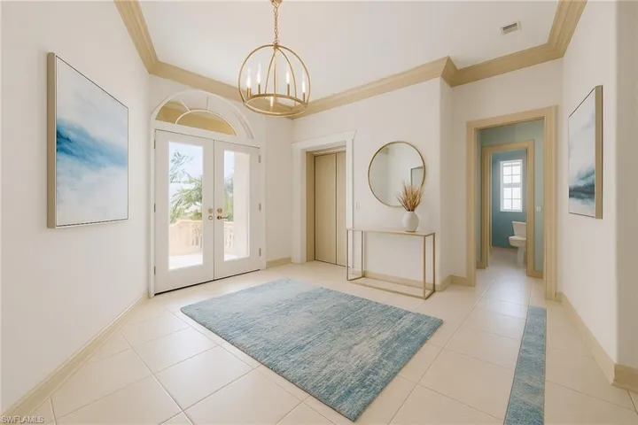 vIRTUALLY STAGED:Entryway with french doors, ornamental molding, light tile patterned flooring, and a chandelier