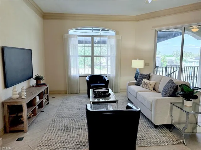 PREVIOUSLY STAGED VIEW:Tiled family room featuring crown molding