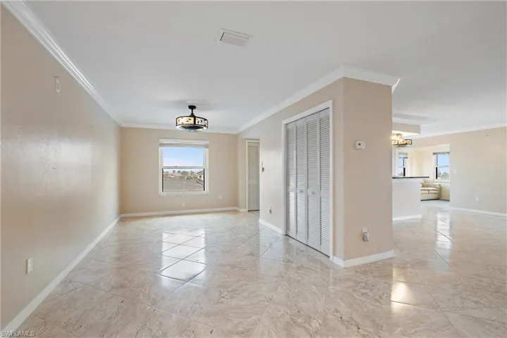Empty room with a chandelier and crown molding