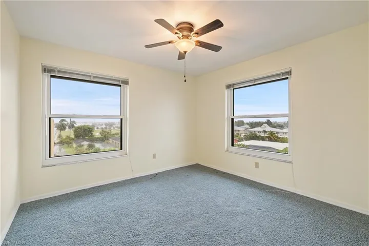 Carpeted spare room with ceiling fan
