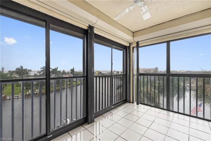 Unfurnished sunroom with ceiling fan, a water view, and a wealth of natural light