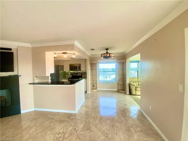 Kitchen featuring decorative backsplash, stainless steel appliances, crown molding, and kitchen peninsula