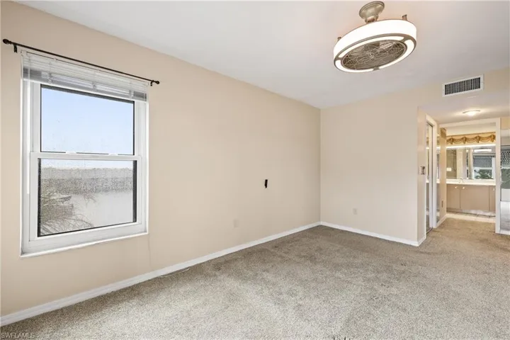 Carpeted spare room featuring a wealth of natural light