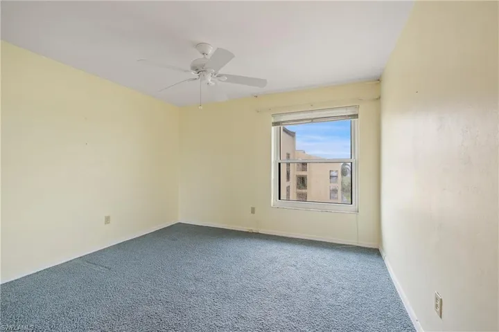 Unfurnished room with ceiling fan and carpet flooring