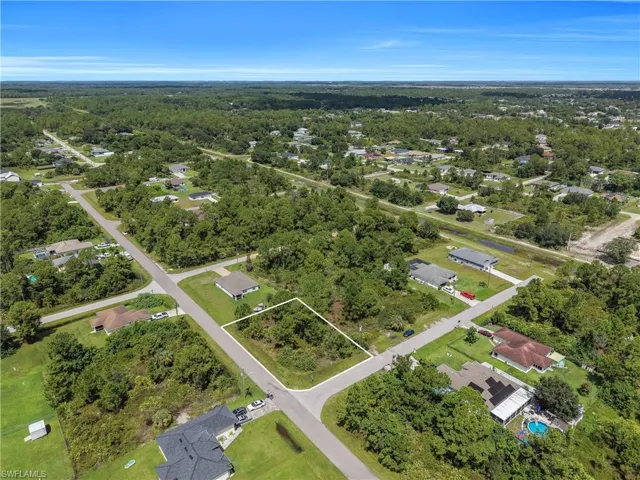 Cleared residential lot with mature trees and paved road frontage
