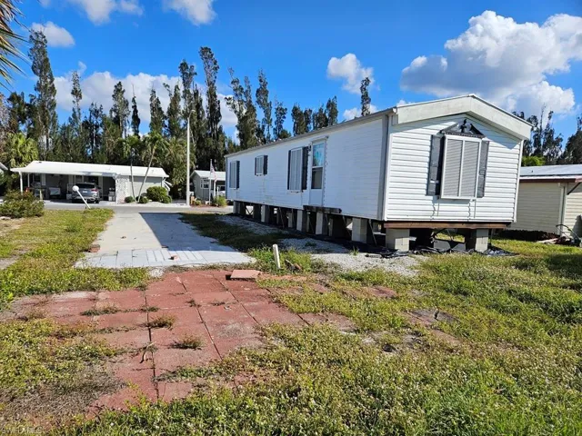 View of property exterior featuring a lawn