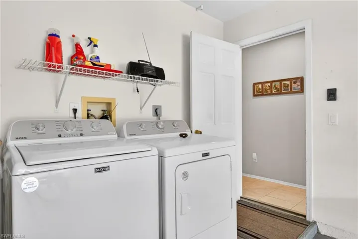 Laundry room featuring washer and clothes dryer and light tile patterned flooring