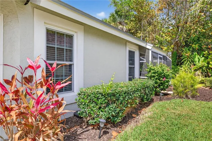 View of side of home with stucco siding and glass enclosure