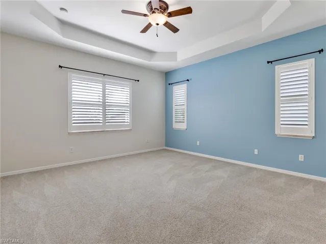 The Primary Bedroom has a tray ceiling, Plantation Shutters, and fan-light combination.