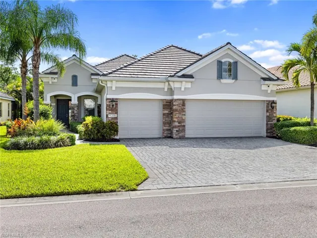 Paver drive, 3 car garage, tile roof, and covered inviting entry