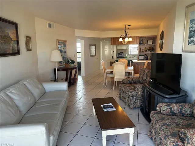 Open-concept floor plan featuring tile flooring, built-in cabinetry, and a tiered peninsula