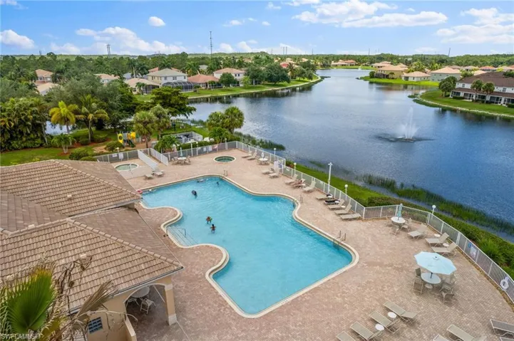 View of swimming pool with a water view and a patio area