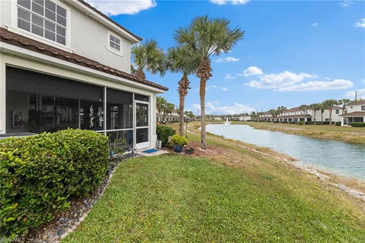 View of yard featuring a sunroom and a water view