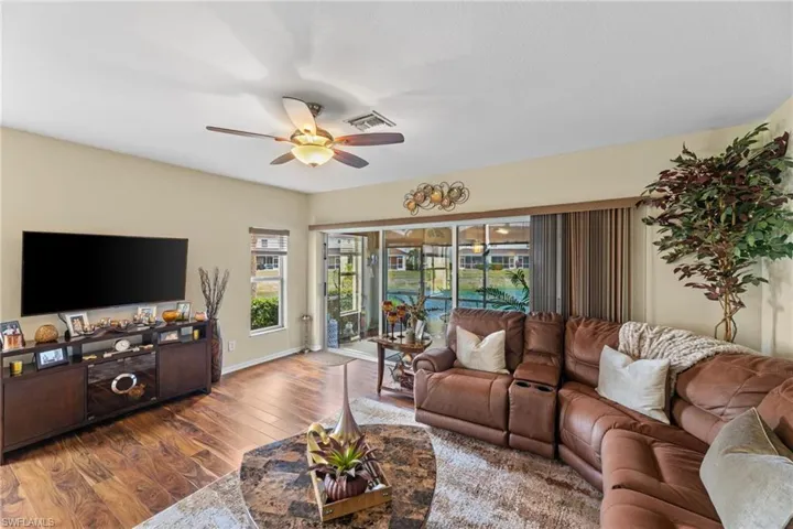 Living room with dark wood-type flooring and ceiling fan