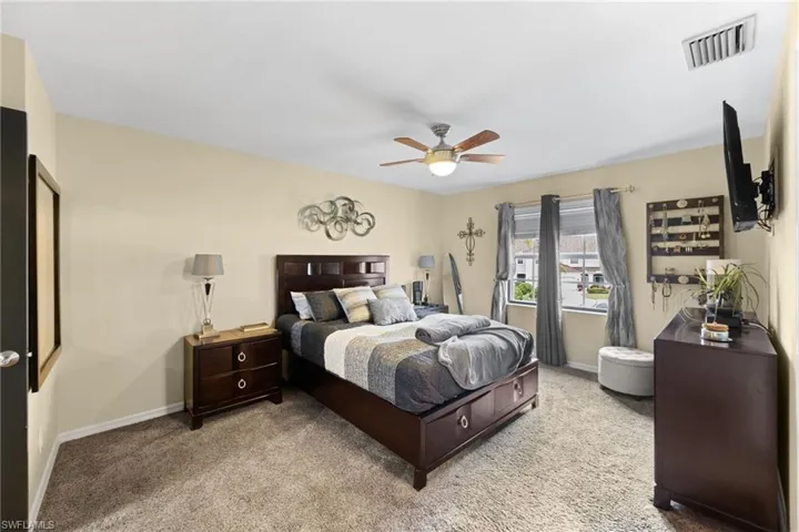 Carpeted bedroom featuring ceiling fan
