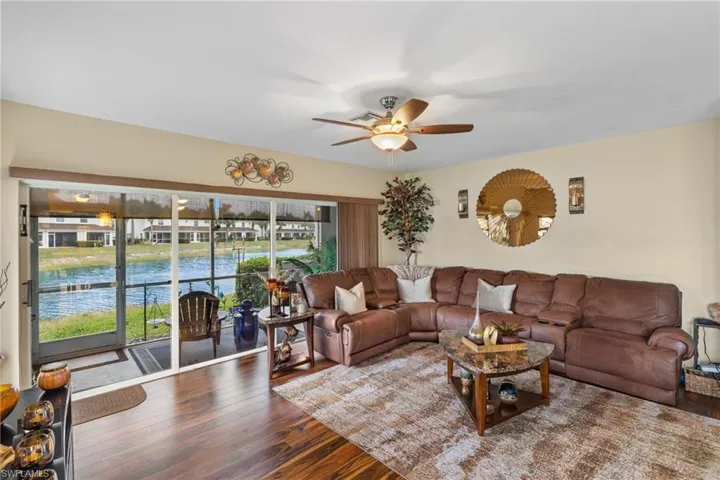 Living room featuring ceiling fan, hardwood / wood-style floors, and a water view