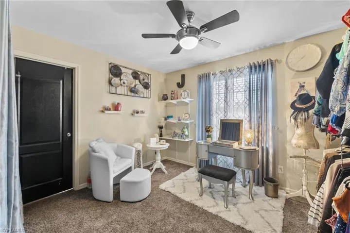 Office area with ceiling fan and carpet