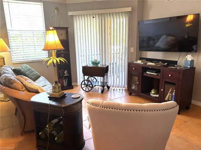 Living room with light tile patterned flooring and baseboards