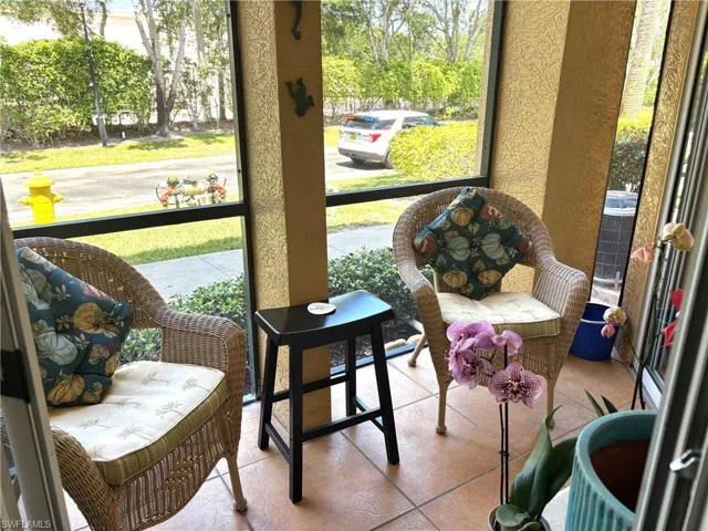 Sunroom / solarium with a textured wall and tile patterned floors