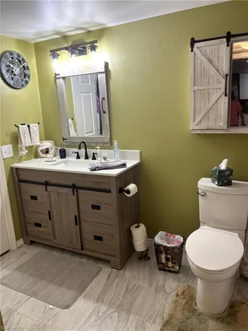 Half bath with a textured wall and vanity
