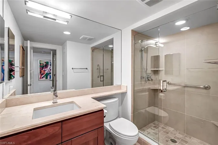 Full bathroom with a shower stall, vanity with granite tops and tile floor