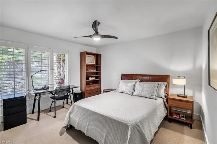 Bedroom featuring plantation shutters. Leather headboard