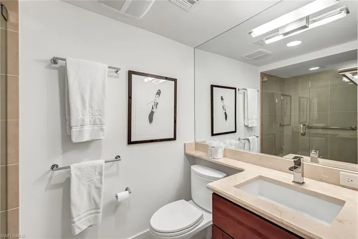 Bathroom featuring vanity, tile shower & walk-in closet with built in drawers
