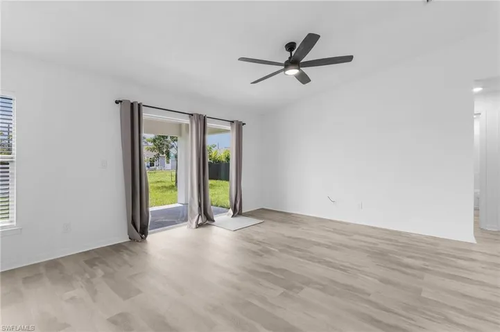 Unfurnished room with light hardwood / wood-style floors and ceiling fan