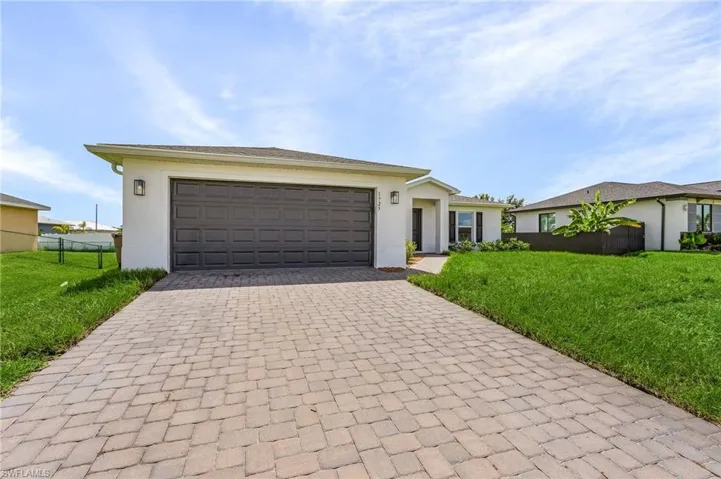 Ranch-style house featuring a garage and a front yard
