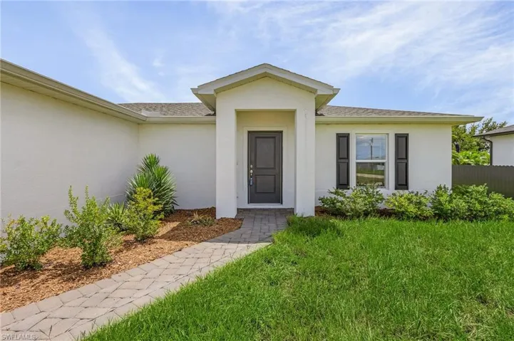 Doorway to property featuring a lawn