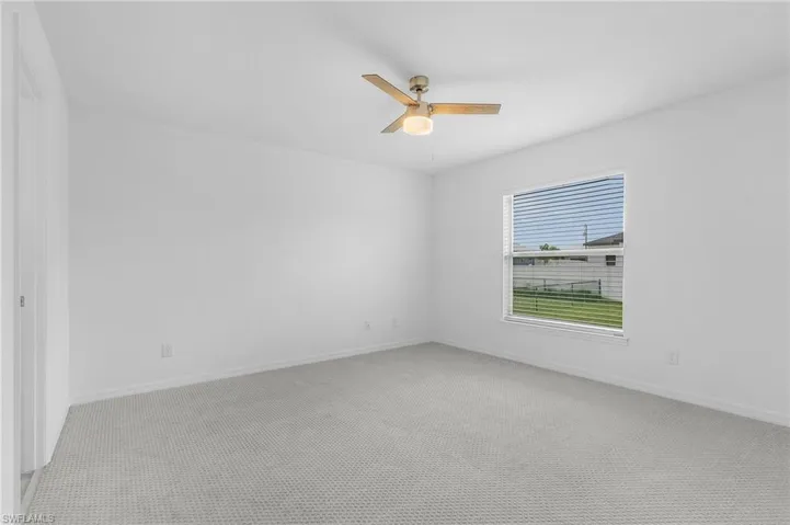 Spare room featuring carpet floors and ceiling fan