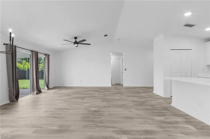 Unfurnished living room featuring lofted ceiling, light hardwood / wood-style flooring, and ceiling fan