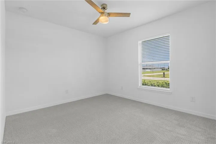 Empty room featuring carpet and ceiling fan