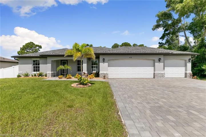 The exterior of the home is highlighted with stone accents, impact resistant windows & lush tropical landscape!