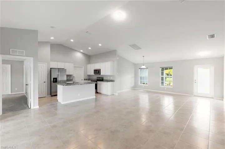 Open Concept Design with neutral porcelain tile flooring, soaring vaulted ceilings & plenty of natural light!
