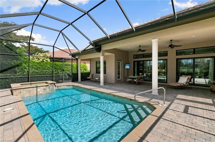 Combined pool / hot tub with a sunroom, glass enclosure, a patio, and outdoor dining area