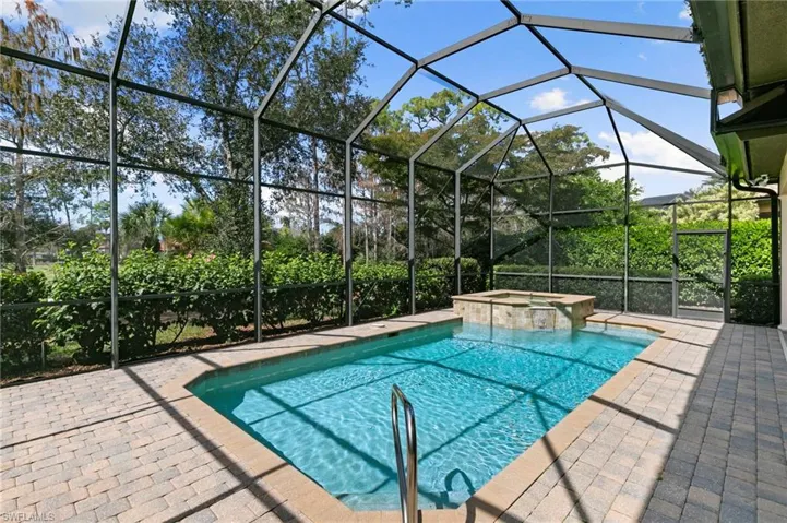 Integrated pool / spa featuring a sunroom, a lanai, and a patio