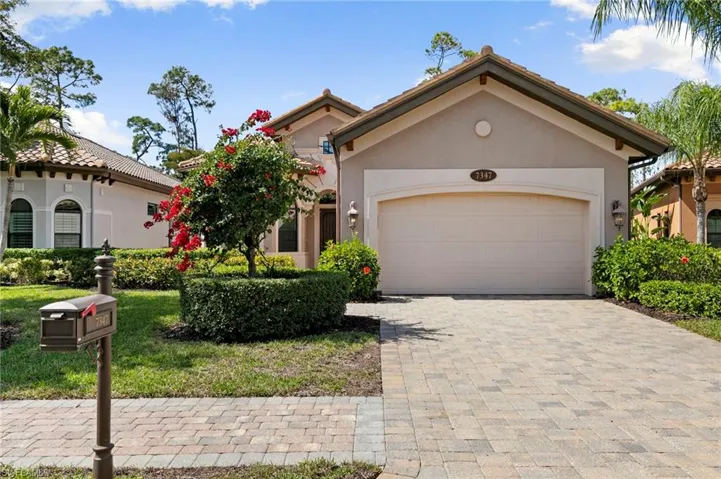 View of front of house with stucco siding, a garage, decorative driveway, and a front lawn